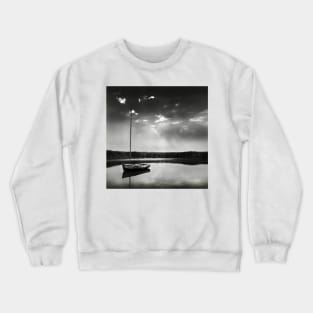 A moored yacht in calm waters at Brancaster Staithe, Norfolk, UK Crewneck Sweatshirt